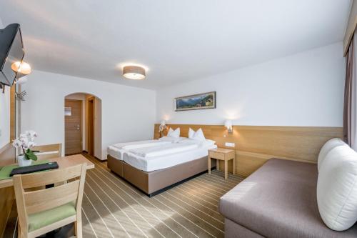 a hotel room with a bed and a couch at Apart Hotel Garni Wieser in Sölden