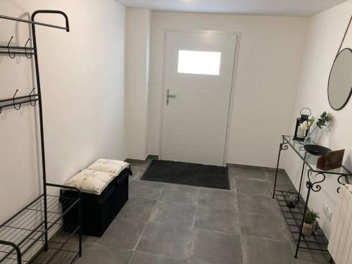 Cette chambre dispose d'une porte blanche et d'un sol. dans l'établissement L’Atelier du Puits Volant, à Meximieux