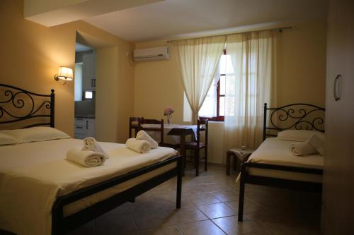una camera d'albergo con due letti e una sala da pranzo di La Casa di Nonna a Qeparo