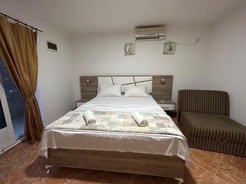 um quarto com uma cama grande e uma cadeira em Christopher's apartments em Ulcinj