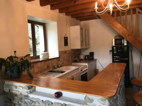 a kitchen with a wooden counter top in a room at maison en pierre atypique sur jardin paysagé 