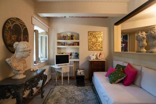 un soggiorno con divano e scrivania di La Casetta di Borgo -Appartamento Peperone a Laiatico