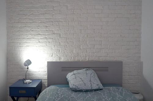 - une chambre avec un lit et un mur en briques blanches dans l'établissement Duguesclin, au Havre