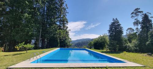 a swimming pool in the middle of a yard with trees at Moradia no Gerês - O Africanista in Soengas
