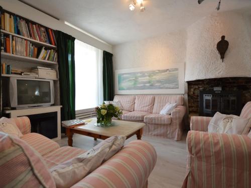 ヘールレンにあるHoliday home in a very quiet residential area of Heerlenのリビングルーム(ピンクのソファ、テレビ付)