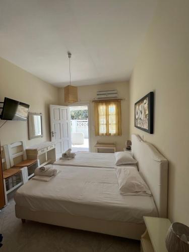 a bedroom with a large bed and a television at Peaceful House in Naxos Chora