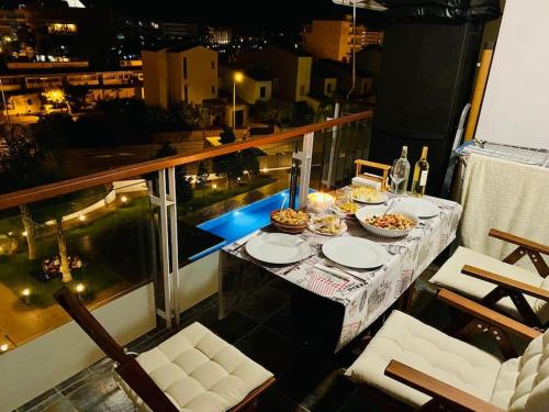 Luminoso apartamento con piscina في روساس: طاولة مع أطباق من الطعام على شرفة