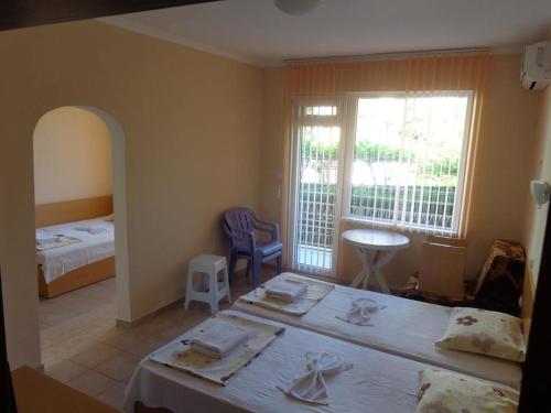 a bedroom with a bed and a room with a table at Guest rooms Rusalka in Kranevo