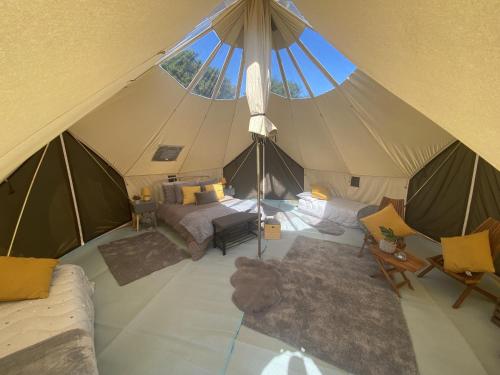 eine Aussicht über ein Zelt mit einem Bett und Stühlen in der Unterkunft Bell Tents at Llanfair Hall in Llanfairpwllgwyngyll