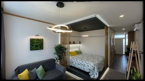 a small bedroom with a bed and a couch at Good Knight Apartman in Szeged