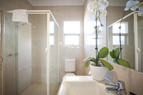 uma casa de banho com um lavatório, um WC e um espelho. em The Bluff Resort Apartments em Encounter Bay