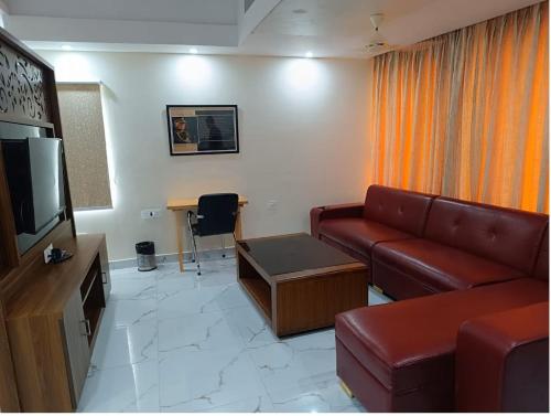 a living room with a couch and a television at Hotel Paramveer in Muzaffarpur