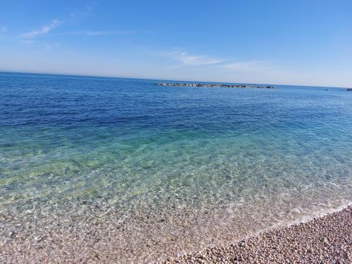 a beach with clear blue water and a rocky shore at B&B BISCEGLIE in Bisceglie