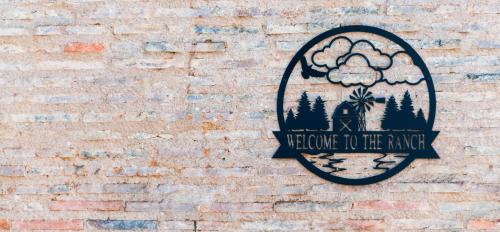 a sign on the side of a brick wall at Hotel Le Ranch in Brûlon