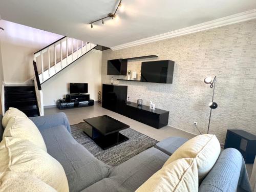 ein Wohnzimmer mit Sofa und Tisch in der Unterkunft Casa Cabo Avelar T4 - Mer in Peniche