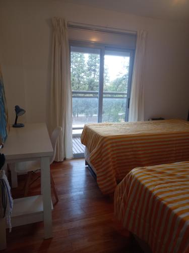 um quarto com 2 camas, uma secretária e uma janela em Departamento en torres del parque em Río Cuarto