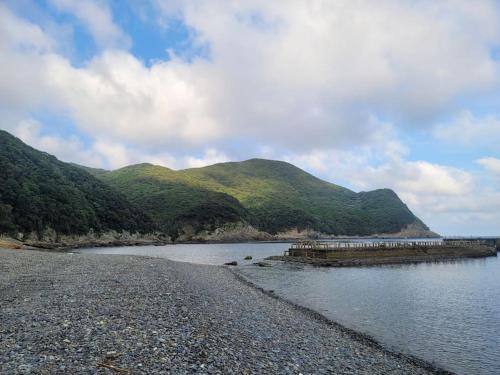 a body of water with mountains in the background at 하루카오후나에 민숙 in Tsushima
