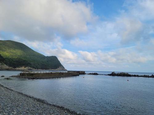 a large body of water with a rocky shoreline at 하루카오후나에 민숙 in Tsushima
