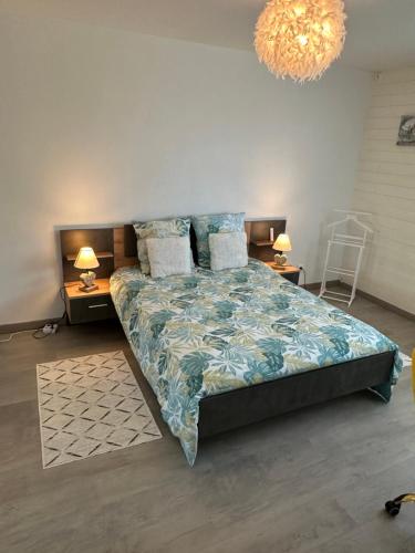 une chambre avec un lit et un lustre dans l'établissement Appartement au bord de mer, à Saint-Brévin-les-Pins
