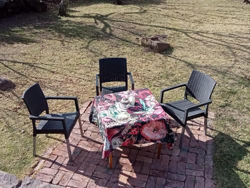 two chairs and a table with a table cloth on it at Cinnamon & Sage Country Cabins in Dullstroom