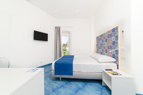 ein weißes Schlafzimmer mit einem Bett und einem Fenster in der Unterkunft La Dimora del Maestro in Amalfi