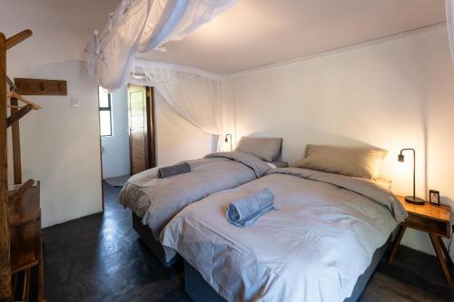 a bedroom with two beds in a room with a window at Kumba Lodge in Praia do Tofo