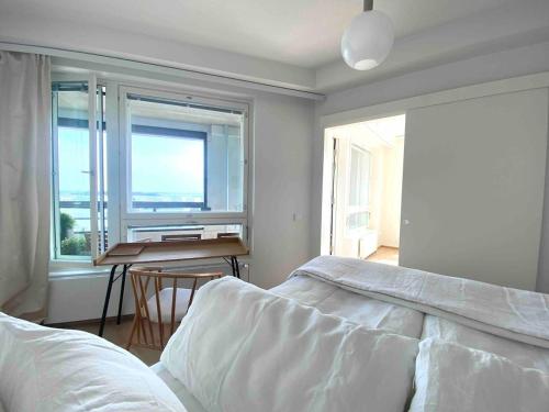 een slaapkamer met een bed, een bureau en een raam bij Goldfinger saunallinen kaksio merinäköalalla 11 krs in Helsinki