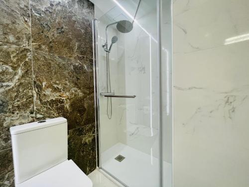 een badkamer met een glazen douche met toilet bij MALTA LUXE in Salou