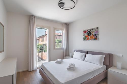 - une chambre blanche avec un lit et une fenêtre dans l'établissement Padova Cozy&Chic Aparment, à Padoue