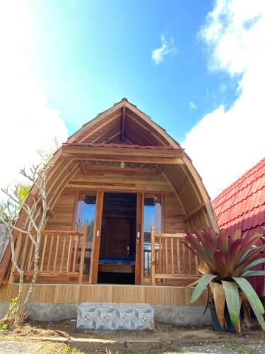 a large wooden cabin with a large glass door at D'Yoga Bamboo House in Kintamani
