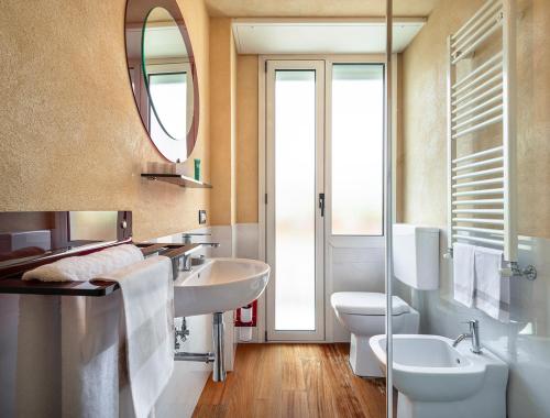 a bathroom with two sinks and a toilet and a mirror at Hotel Rosa Bianca in Rapallo