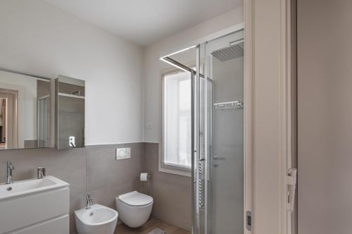 La salle de bains est pourvue de toilettes, d'un lavabo et d'une douche. dans l'établissement Padova Cozy&Chic Aparment, à Padoue