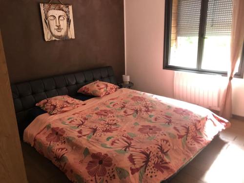 1 dormitorio con 1 cama con manta rosa y ventana en la chainade, en Marennes