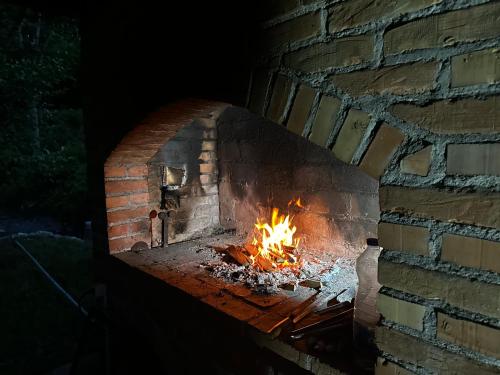 Un horno de ladrillo con fuego. en Tronoska Oaza Korenita, Loznica en Loznica