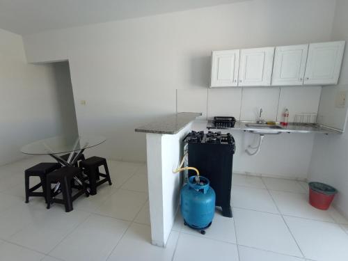 eine Küche mit einer Theke und einem Tisch mit Stühlen in der Unterkunft Apartamento Mobiliado no Centro da Cidade in Imperatriz