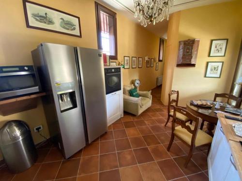 a kitchen with a stainless steel refrigerator and a table at Lodge Villa Maria in Teolo