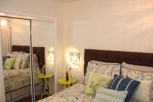 een slaapkamer met een bed met kussens en een spiegel bij Casa Amarilla , Walk to Monterey Aquarium, Cannery Row, Restaurants and Shopping in Pacific Grove