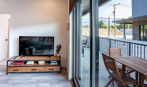 a living room with a flat screen tv on a balcony at Summit Place - Condo With Mountain Views in Revelstoke