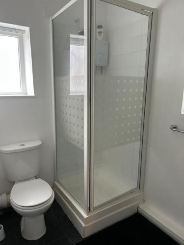 a bathroom with a toilet and a glass shower at Bradford Service accommodation in Bradford