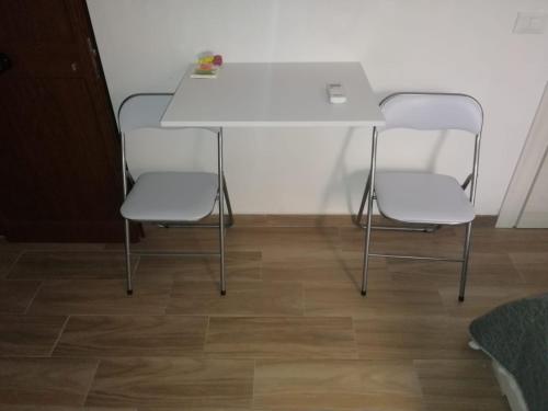 un tavolo bianco e 4 sedie in una stanza di La casa dei Fiori a Trapani