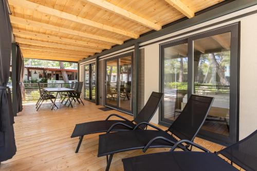 una veranda riparata con sedie e tavolo di Mobile Homes Ljutić a Biograd na Moru
