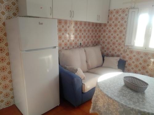 eine Küche mit einem Sofa, einem Kühlschrank und einem Tisch in der Unterkunft Casas da Saibreira - nº2 in Elvas