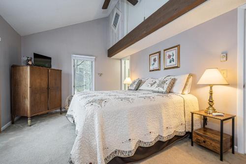 a bedroom with a bed and a table with a lamp at Beary Relaxing in McHenry