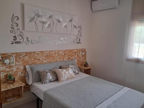 Un dormitorio con una cama y una pared con flores. en CASA MARIA CINTA en Deltebre
