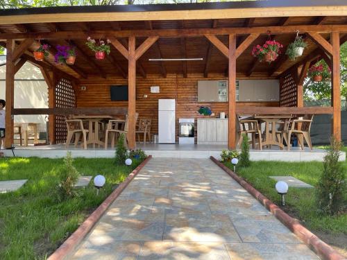 a large wooden pavilion with chairs and tables at CAZARE EDI in Corbu