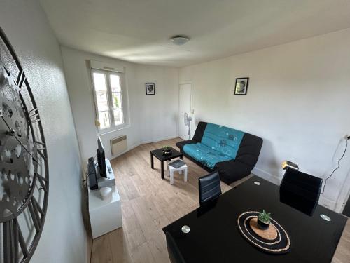 a living room with a blue couch and a table at La clé de FA - Fibre Wifi - Parking - Calme et tranquilité in Troyes