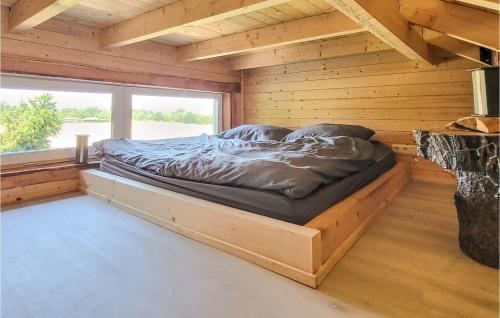 a bed in a wooden room with a large window at Gorgeous Home In Harzgerode With Kitchen in Harzgerode