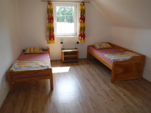 two beds in a small room with a window at Chalupa Sababsh Třebušín 