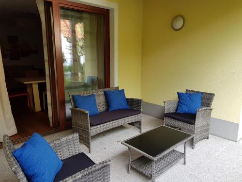 a patio with chairs and a table and blue pillows at Haus Nora by Globalimmoservice in Bad Kleinkirchheim
