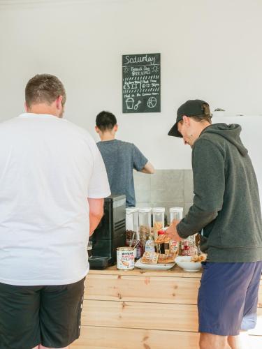two people standing at a counter preparing food at Cinnamon Sally Backpackers Hostel in Rīga
